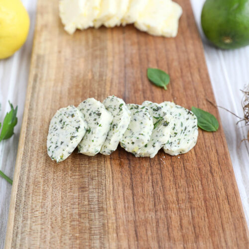An image of garlic and herb butter on a wooden board.
