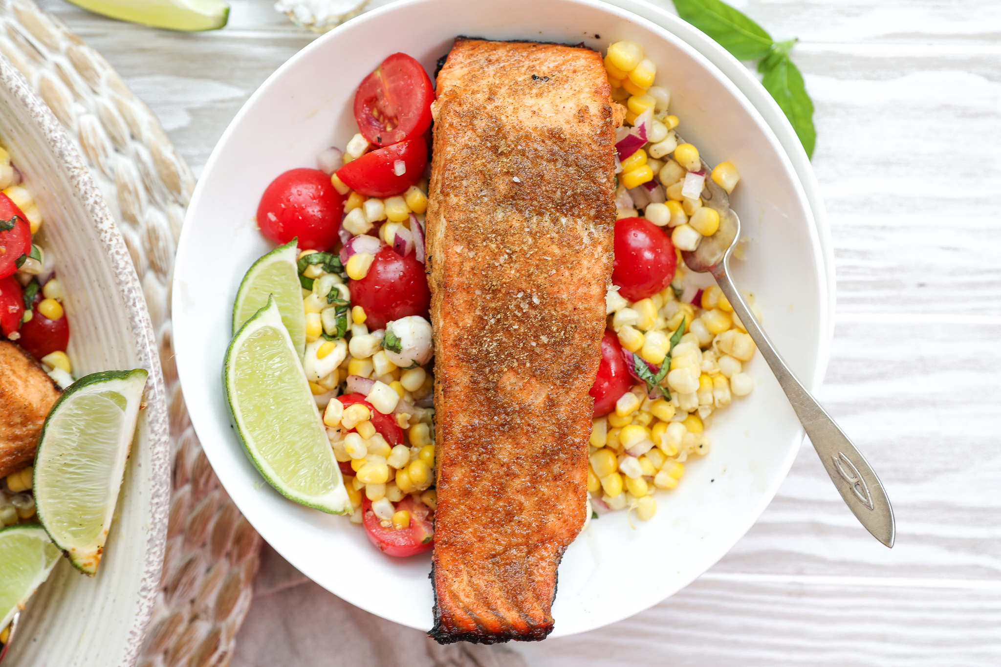 An overhead image of grilled salmon over summer corn salad.