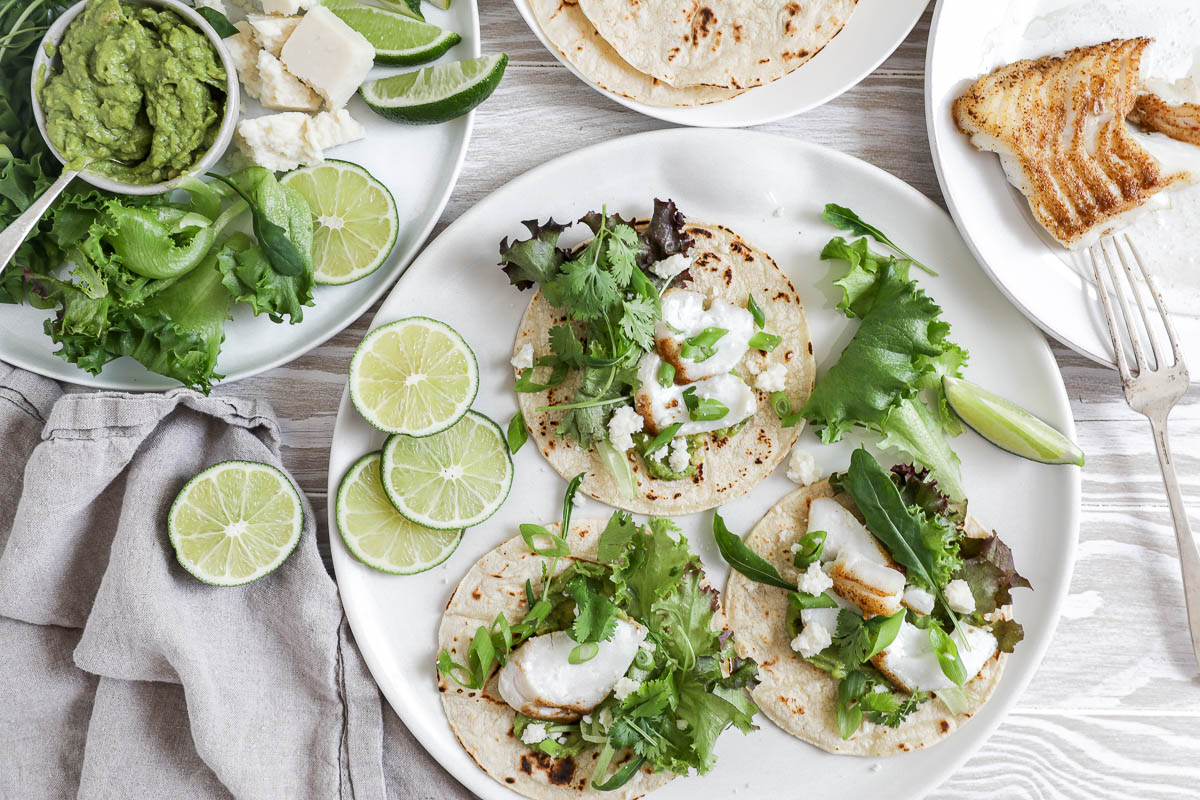 An image of fish tacos with lime slices