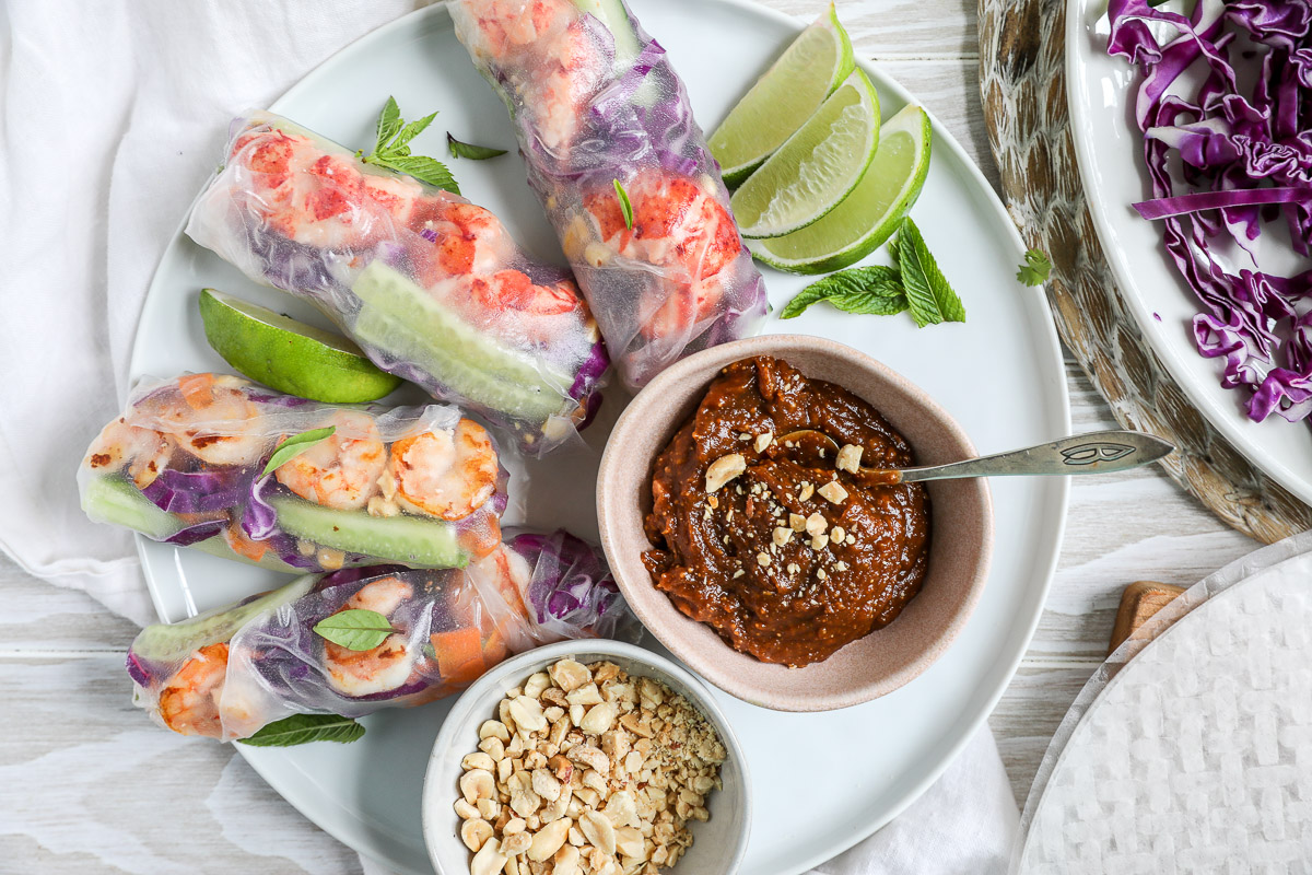An overhead image of fresh summer rolls with peanut sauce