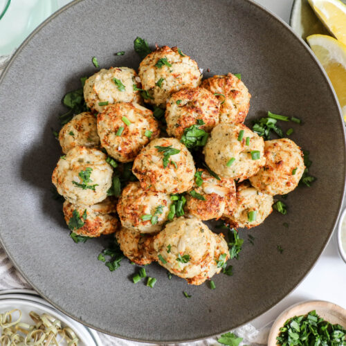 An overhead image of a bowl of mini crab cakes.