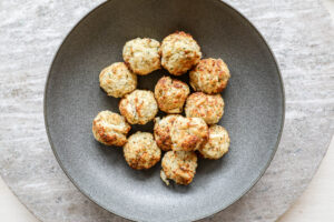 An image of air fried crab cakes in a grey bowl. 