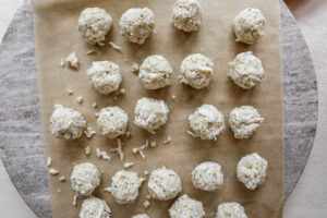 An image of crab cakes after they've bene assembled on parchment paper.