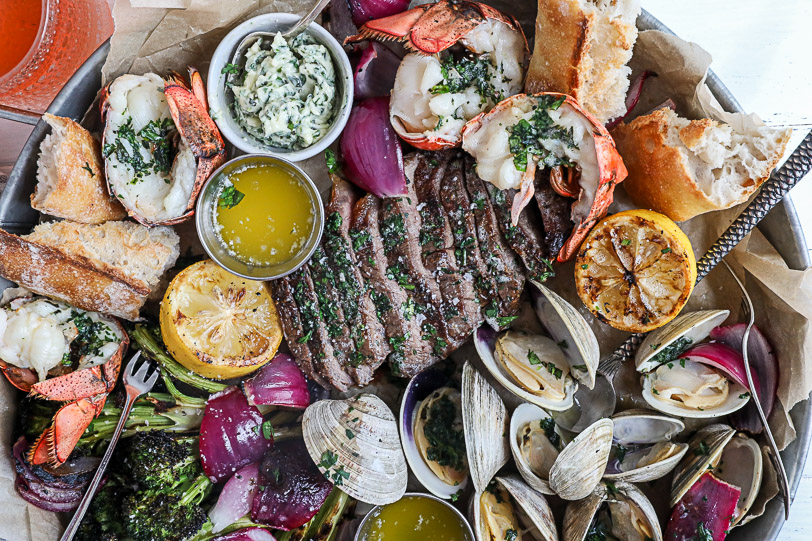 A surf and turf platter with steak, lobster and clams