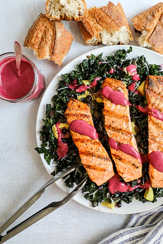 An overhead image of a salmon and kale salad with a wild blueberry vinaigrette. 