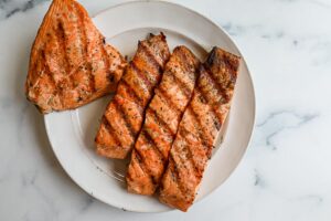 An image of grilled salmon on a white plate.