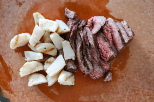 An image of scallops and steak.