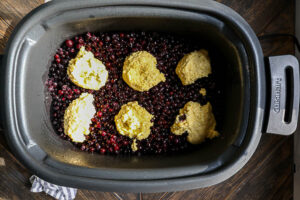 An overhead image of wild blueberry cobbler in the slow cooker before cooking.