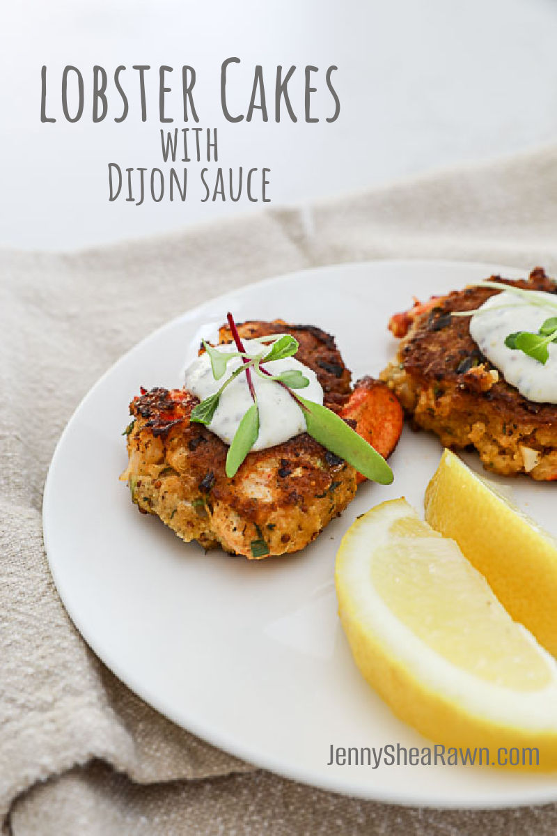 An image of lobster cakes on a white plate with mustard sauce.