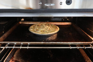 An image of the quiche going into the oven. 