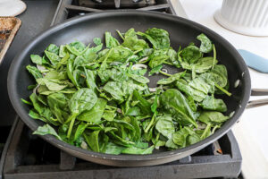 An image of spinach and shallots sauteing. 