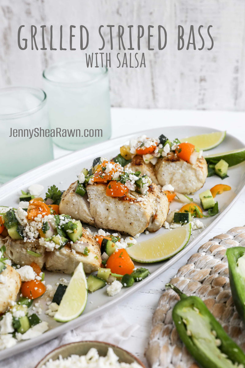 An image of a striped bass with salsa recipe featured on a white plate with lime wedges.