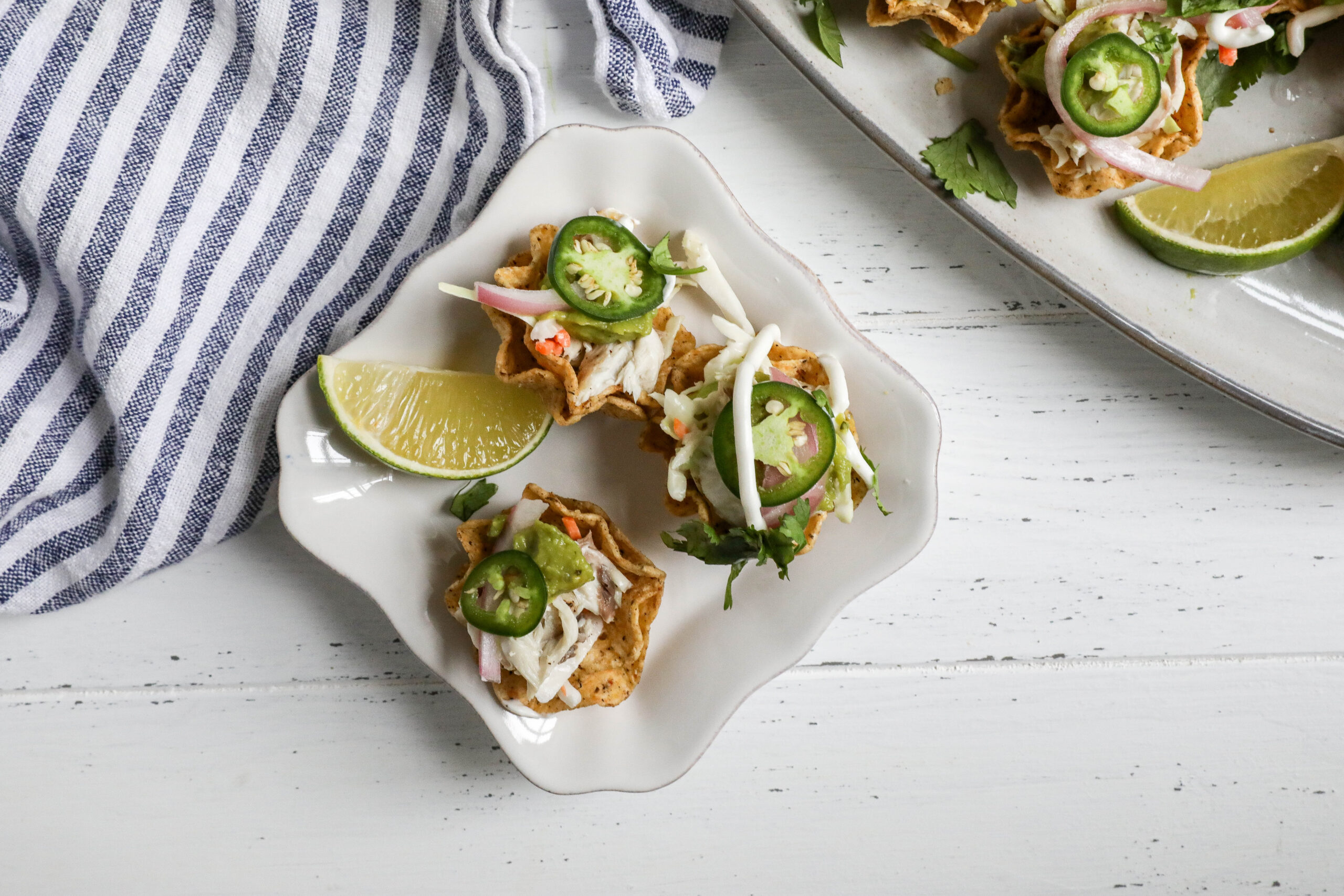 An overhead image of bluefish taco bites on a small square white plate.