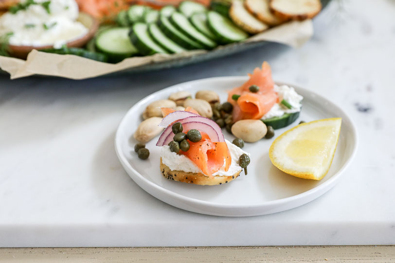 An image of a bagel crisp topped with cream cheese, smoked salmon, capers and red onion. 