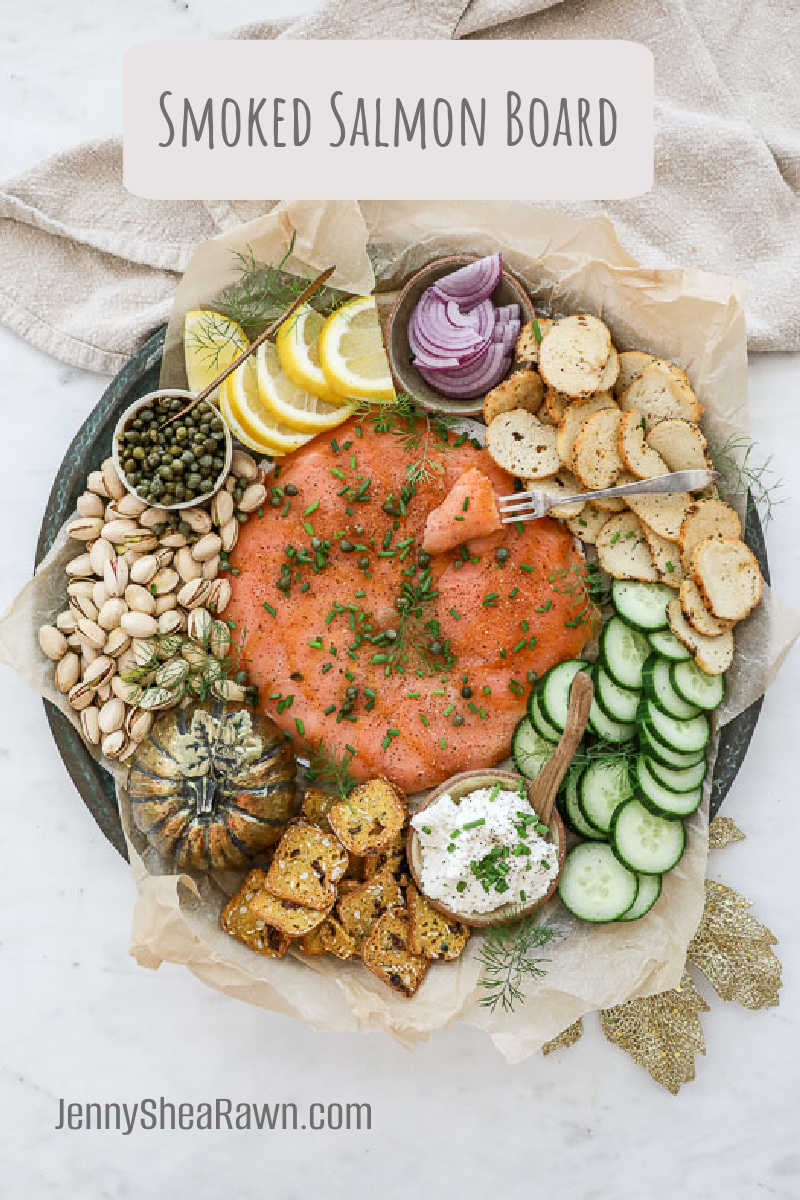 An image of a smoked salmon seacuterie board on a circular platter with fall leaves and a golden pumpkin. 