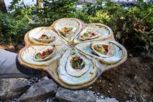 An image of 6 grilled oysters on an oyster platter