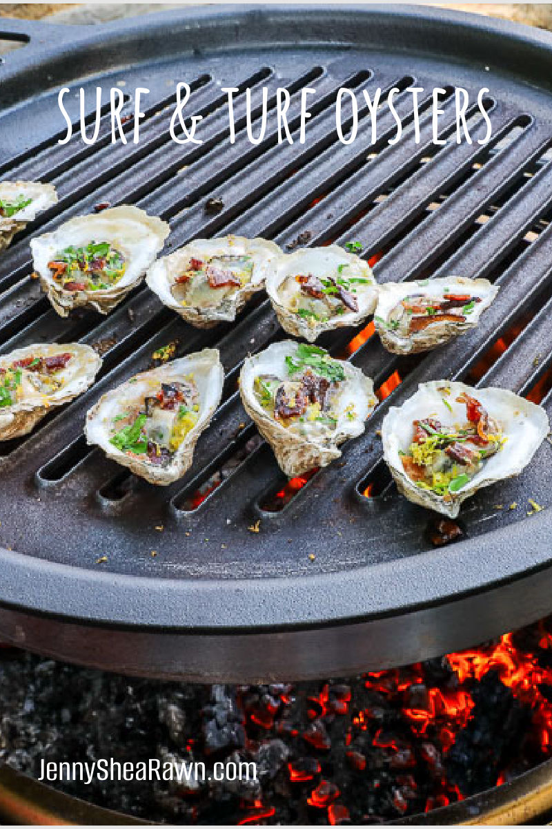 An image of oysters with bacon, parsley and lemon zest on a grill grate over an open flame. 