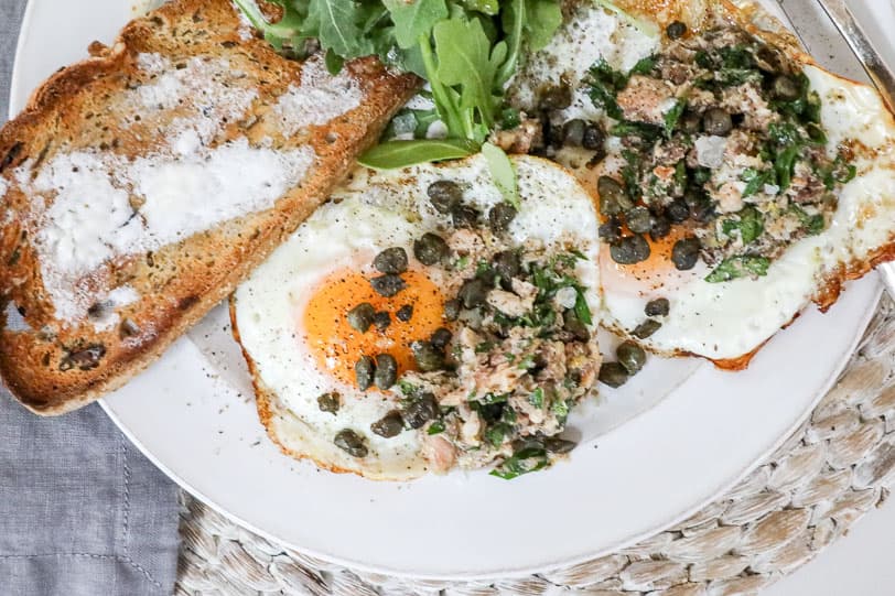 An image of eggs over easy with sardines.