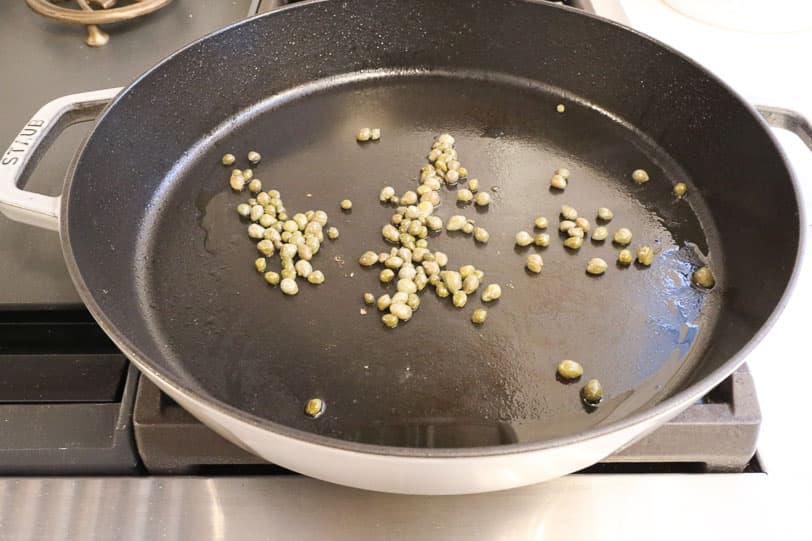 An image of capers in a frying pan. 