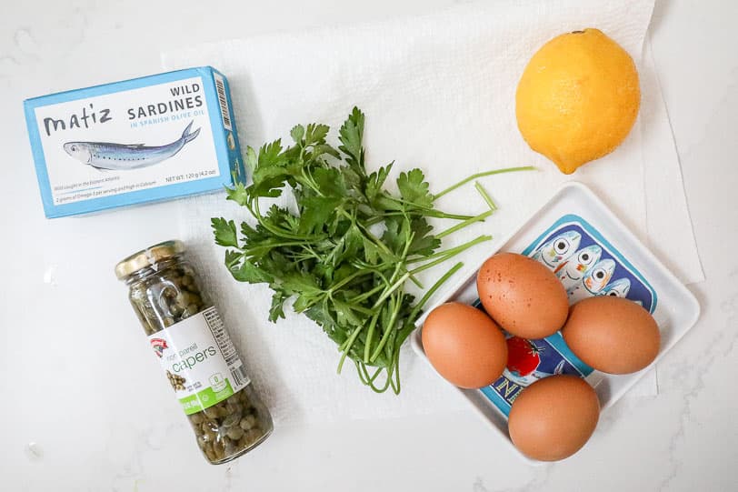 An overhead image of ingredients for making a sardines with eggs dish. 