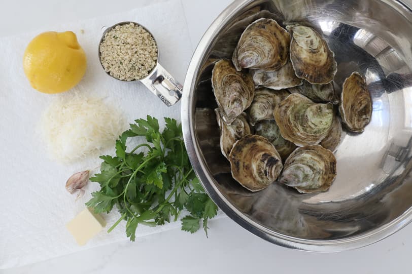 An image of ingredients needed to make roasted oysters: oysters, butter, panko crumbs, parsley and lemon. 