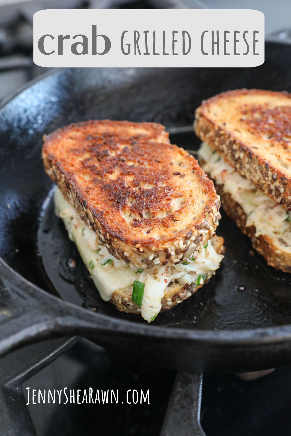 An image of a crab grilled cheese on a cast-iron skillet. 