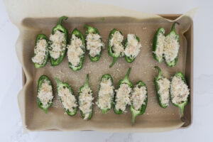 An overhead image of jalapenos stuffed with crab meat and panko crumbs. 