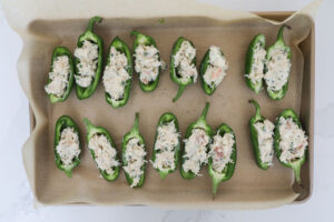 An overhead image of crab stuffed jalapenos getting ready to go into the oven.