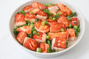 An image of salmon bites with asparagus.